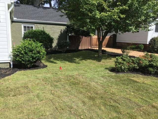 A lush green lawn in front of a house.
