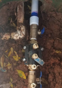 A close up of a water pipe in the dirt