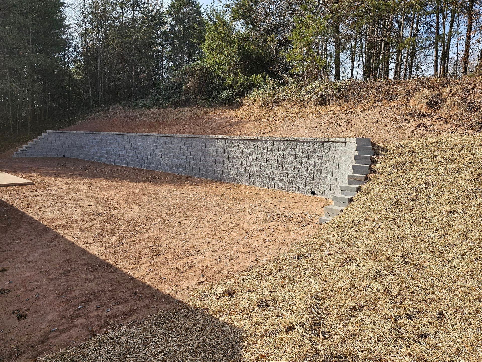 A stone wall with stairs leading up to it is sitting on top of a dirt hill gaffney