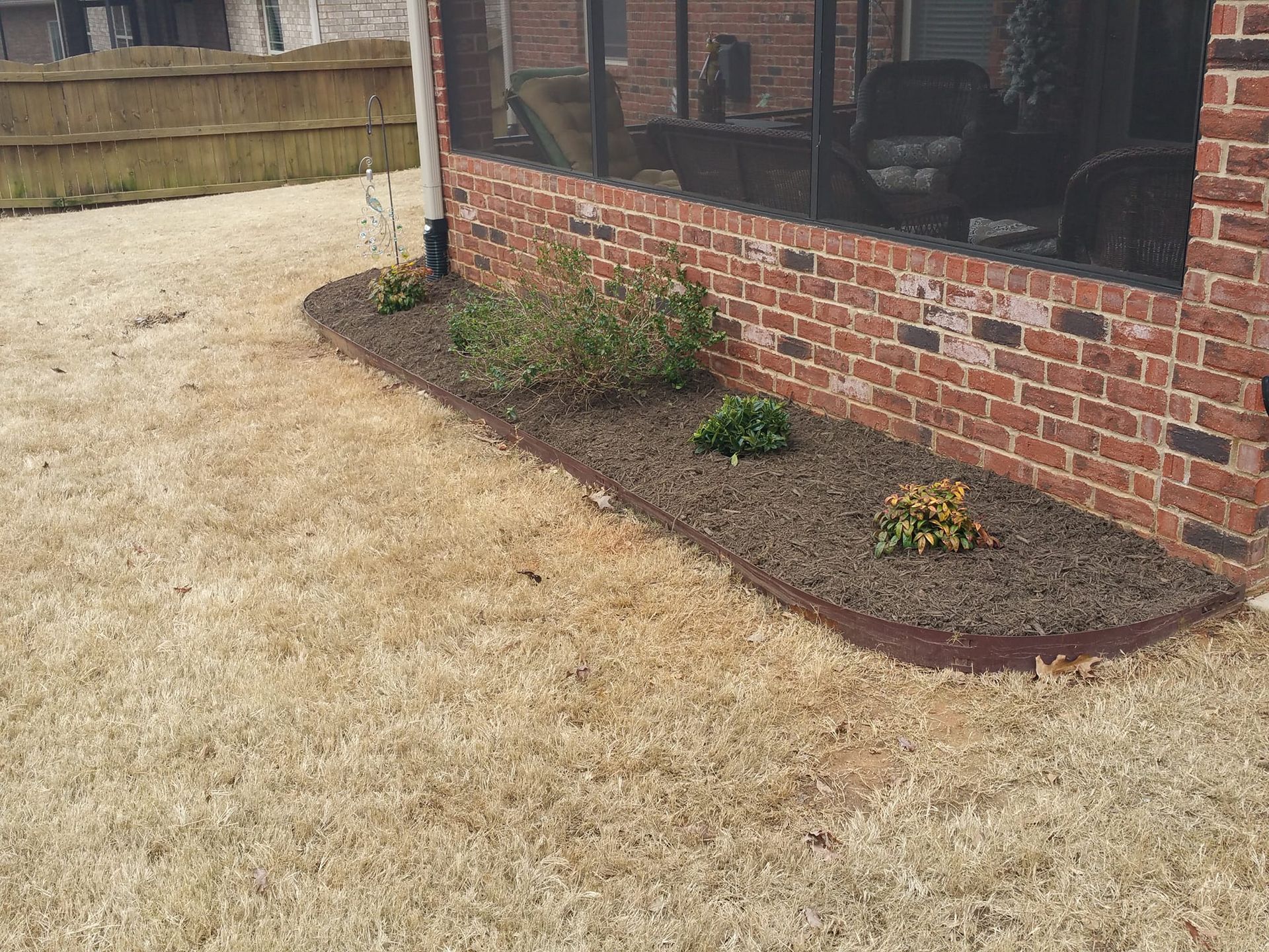 A brick house with a screened in porch and a garden in front of it. downtown spartanburg 
