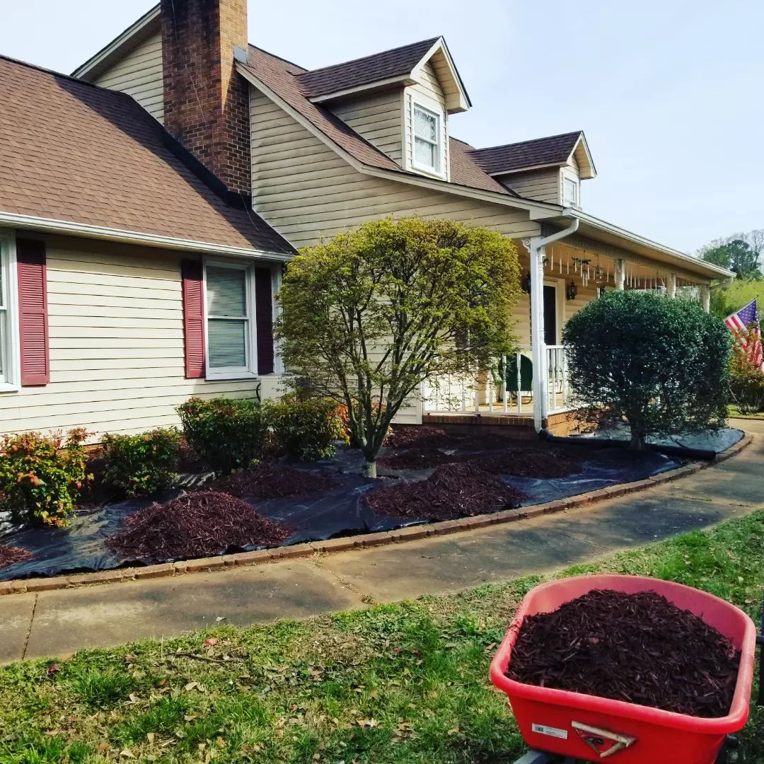 A house with a wheelbarrow full of mulch in front of it duncan