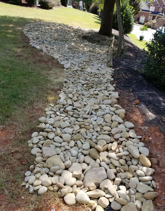 A pile of rocks is sitting on the ground in a yard.