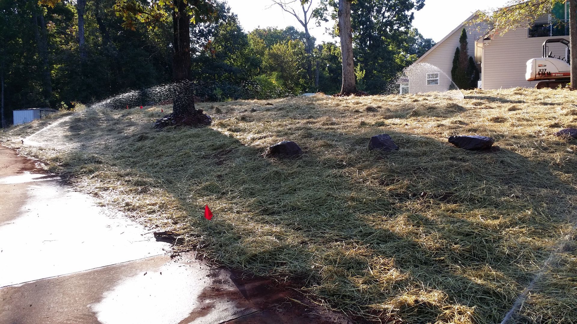 A grassy hillside with a house in the background