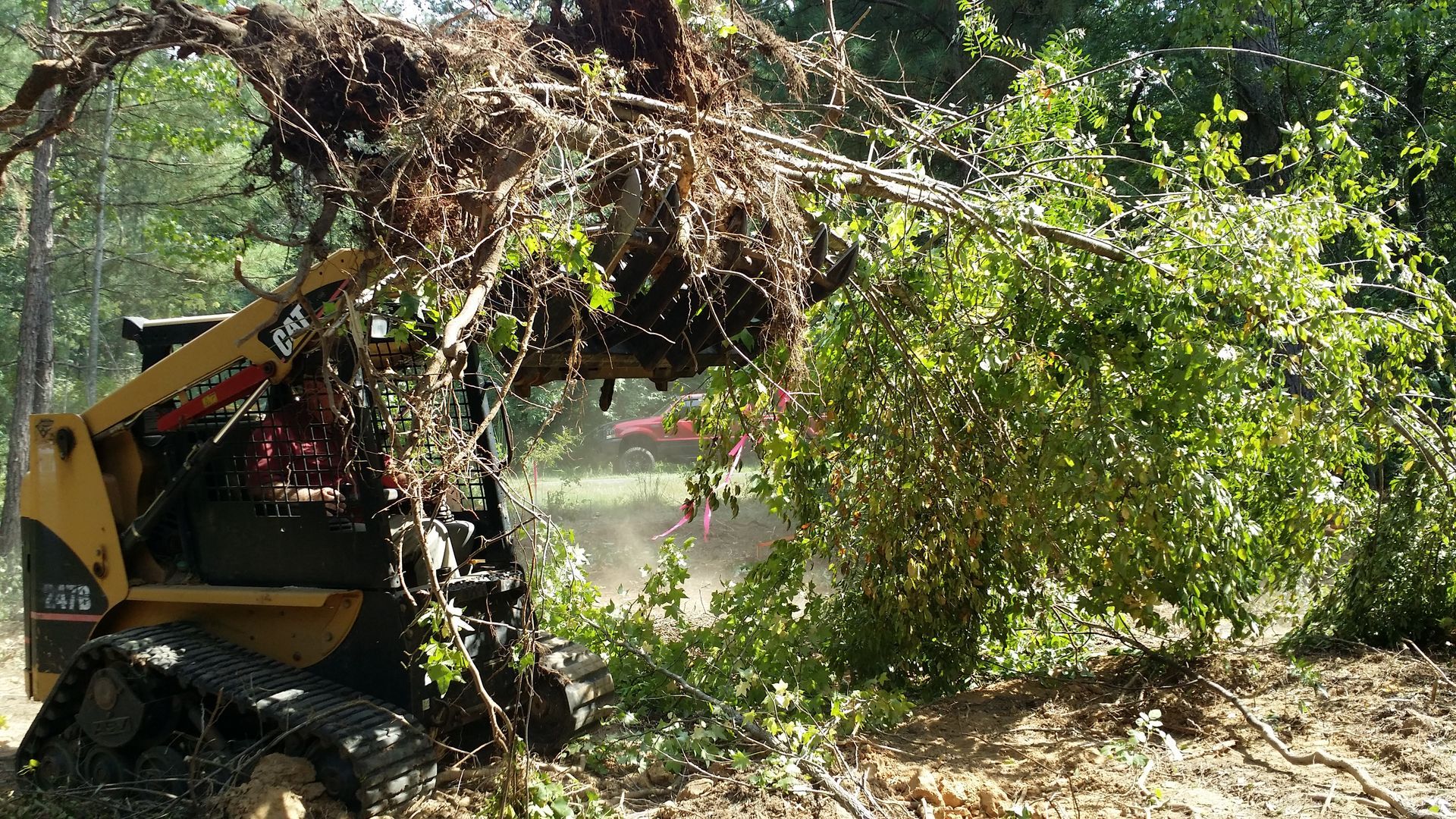 A bulldozer is cutting down a tree in a field spartanburg 
