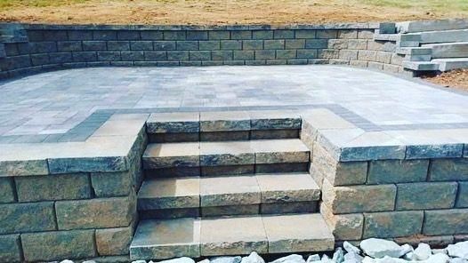 A brick wall with stairs leading up to a patio.