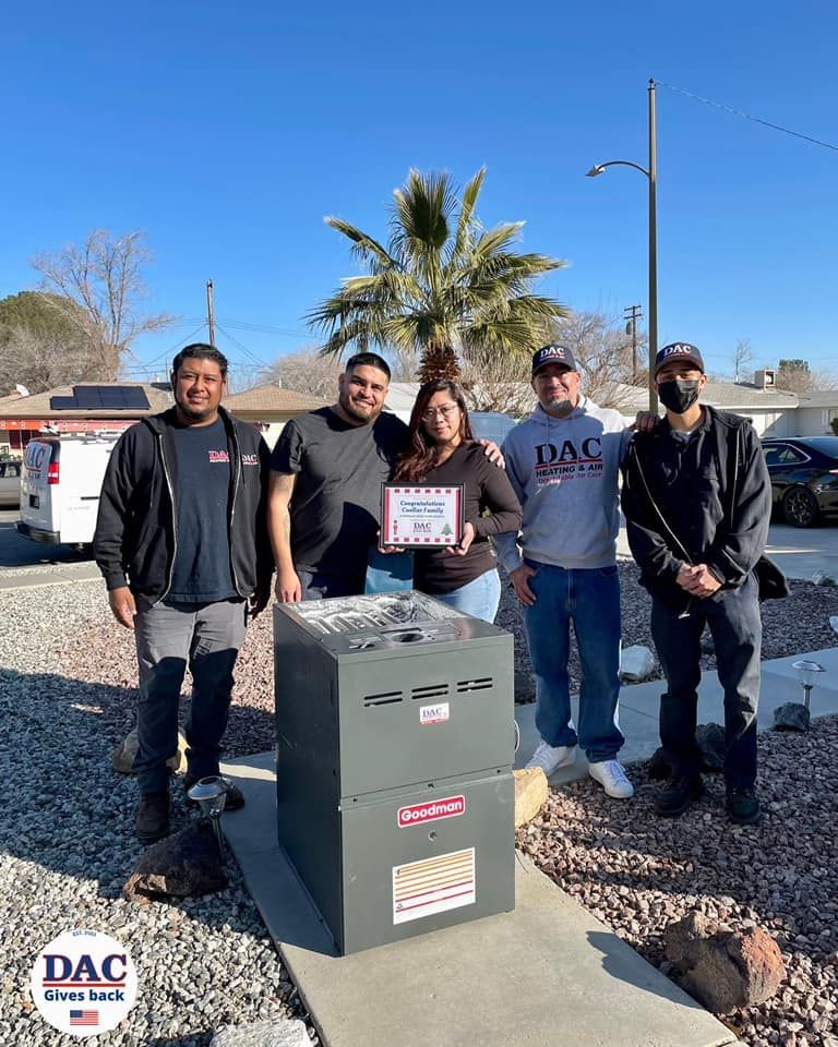 A group of people are posing for a picture in front of an air conditioner.