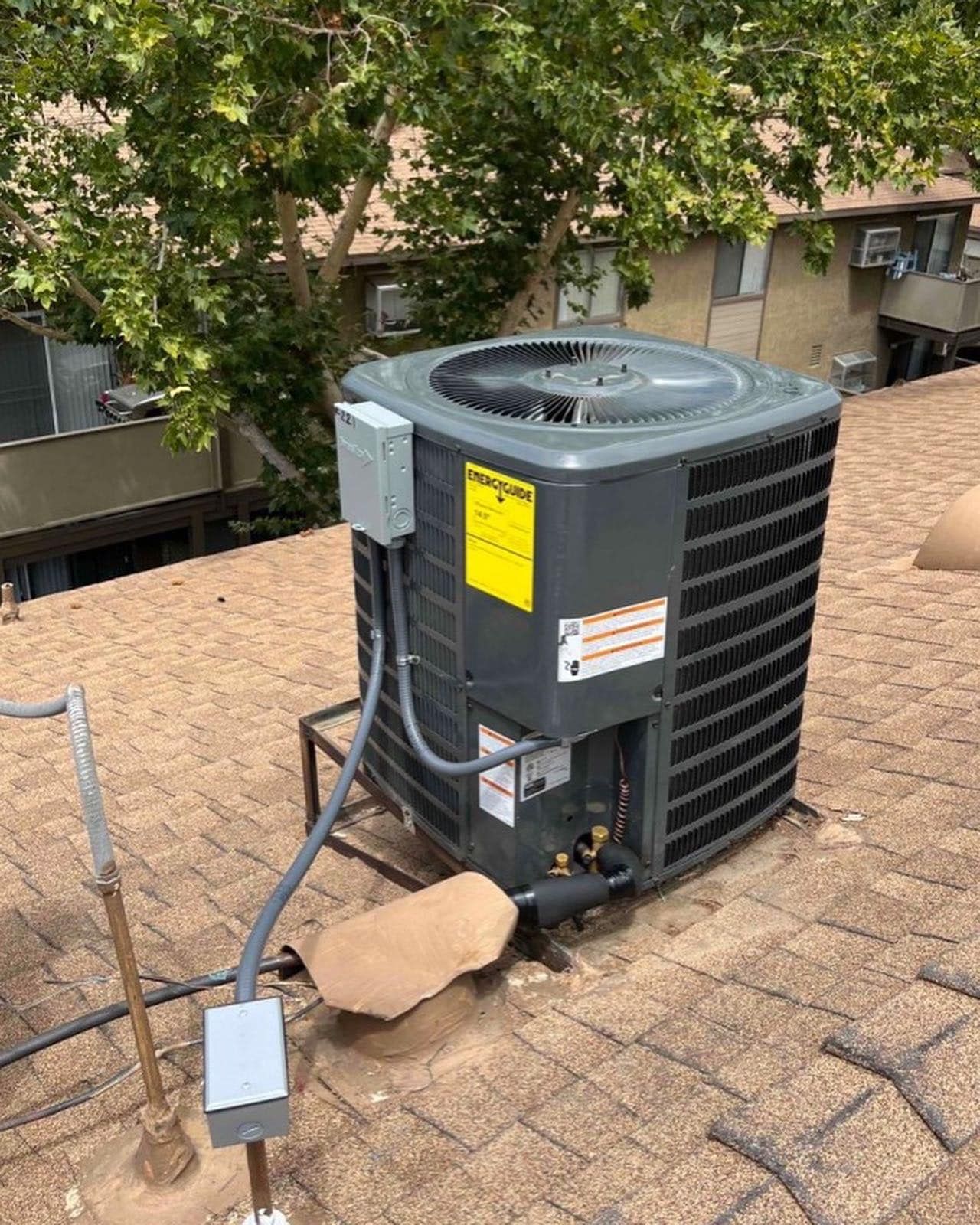 A large air conditioner is sitting on top of a roof.