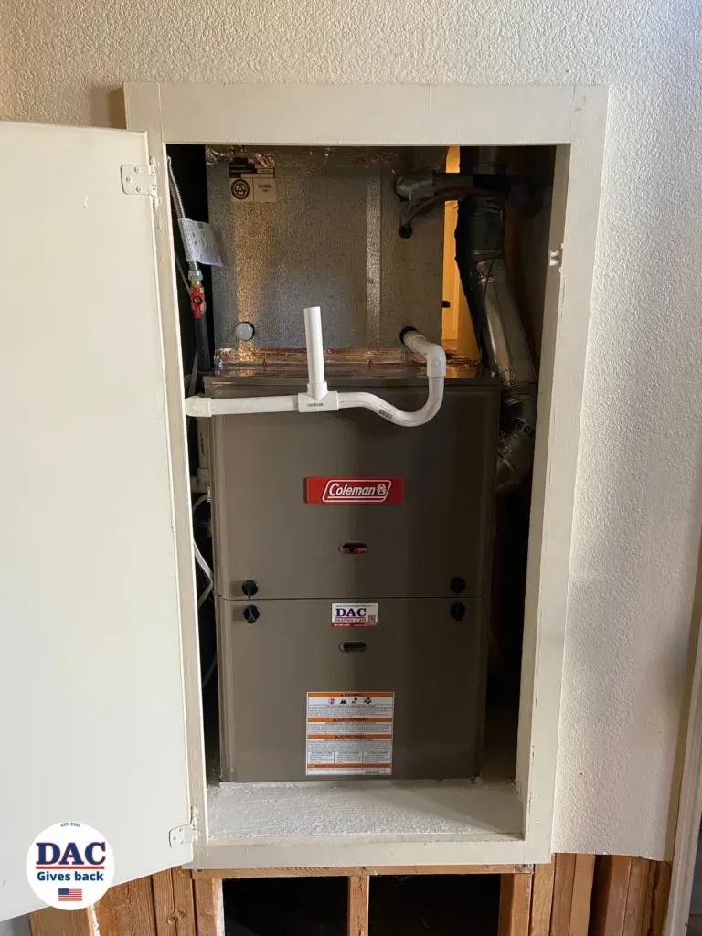 A furnace is sitting inside of a cabinet in a room.