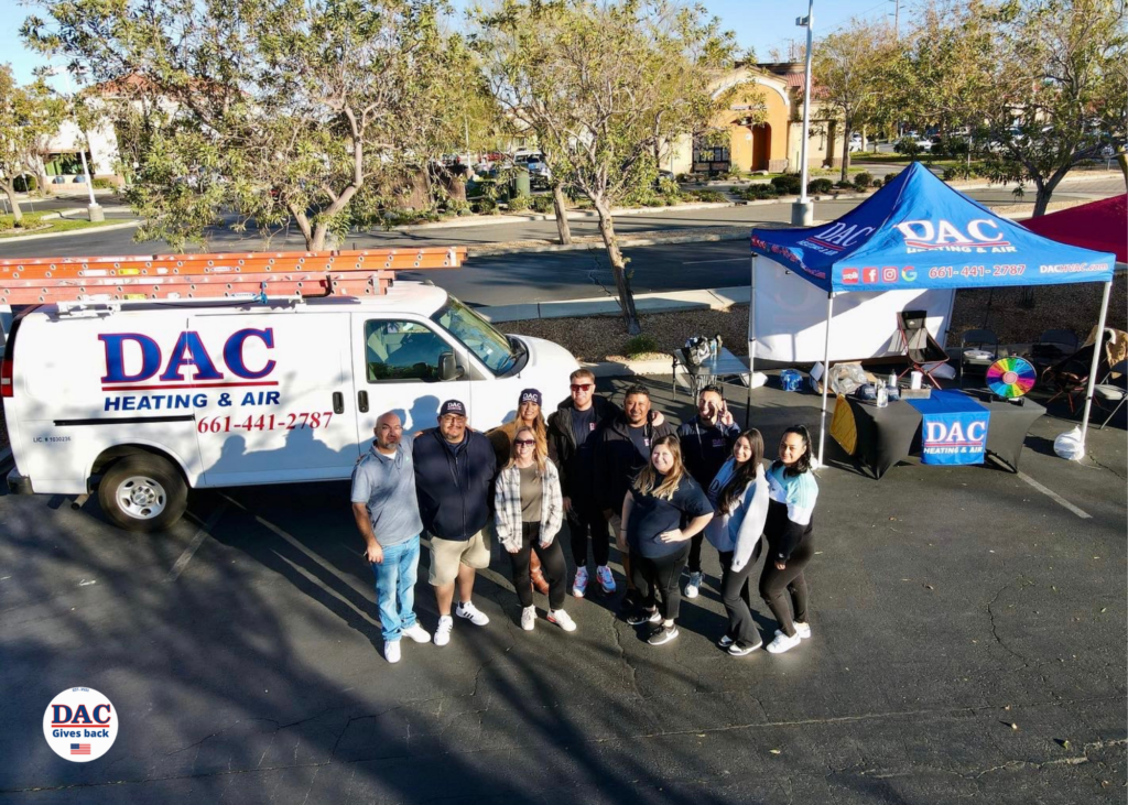 A group of people are posing for a picture in front of a dac van.
