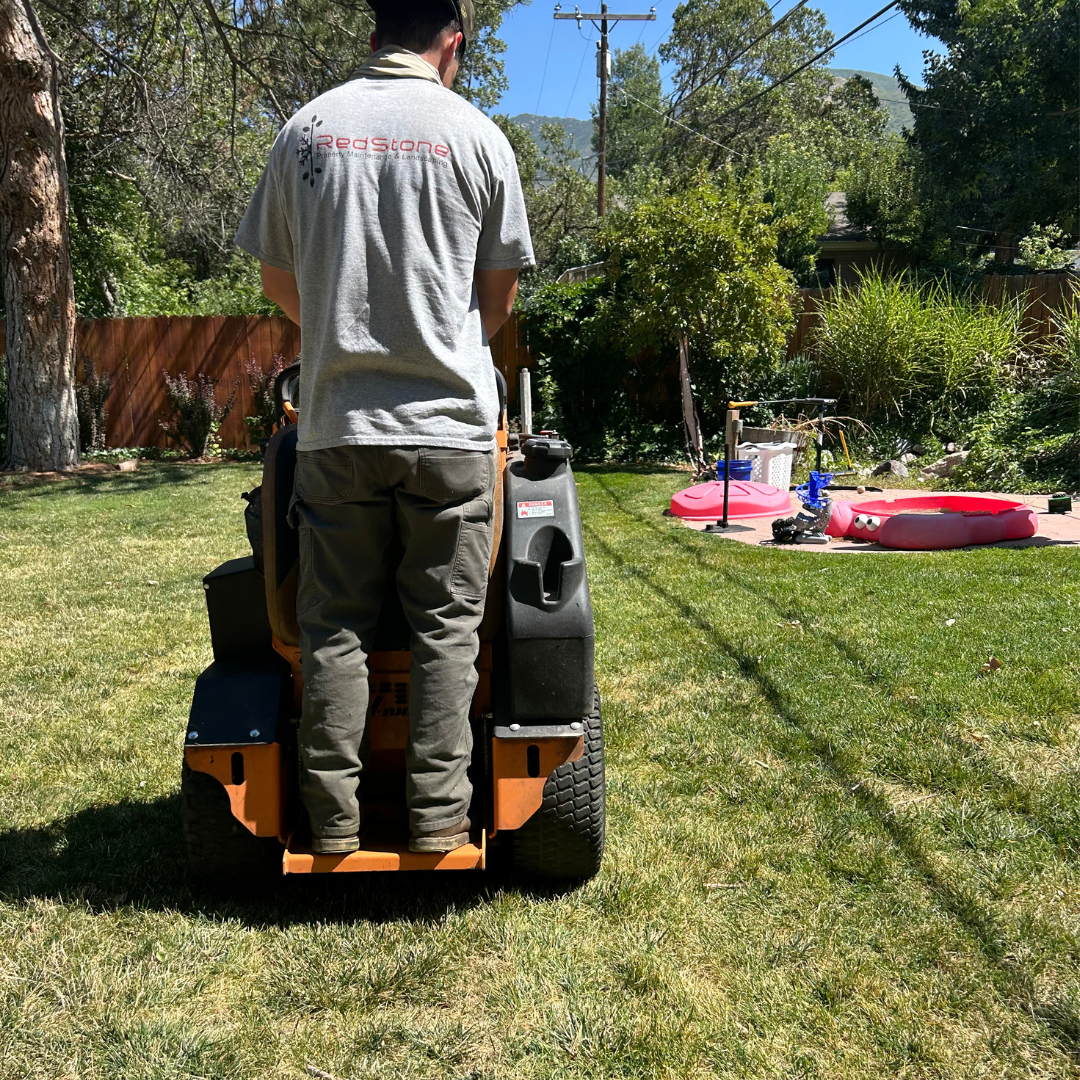 Redstone landscaper performing lawn mowing and property maintenance in a residential yard in bountiful utah