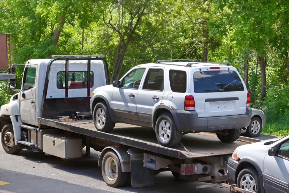 White Suv is Being Towed by a Tow Truck — SNS Custom Fabrication in Bundaberg East, QLD