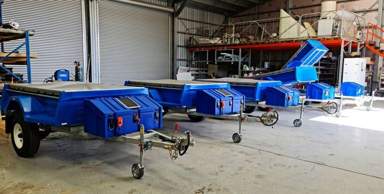 A Row of Blue Trailers Are Parked in a Warehouse — SNS Custom Fabrication in Bundaberg East, QLD