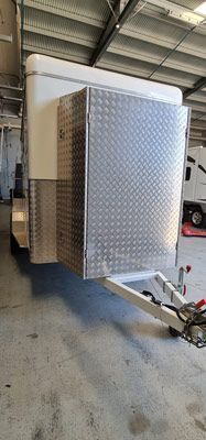 A Trailer is Parked in a Garage Next to a Car — SNS Custom Fabrication in Bundaberg East, QLD