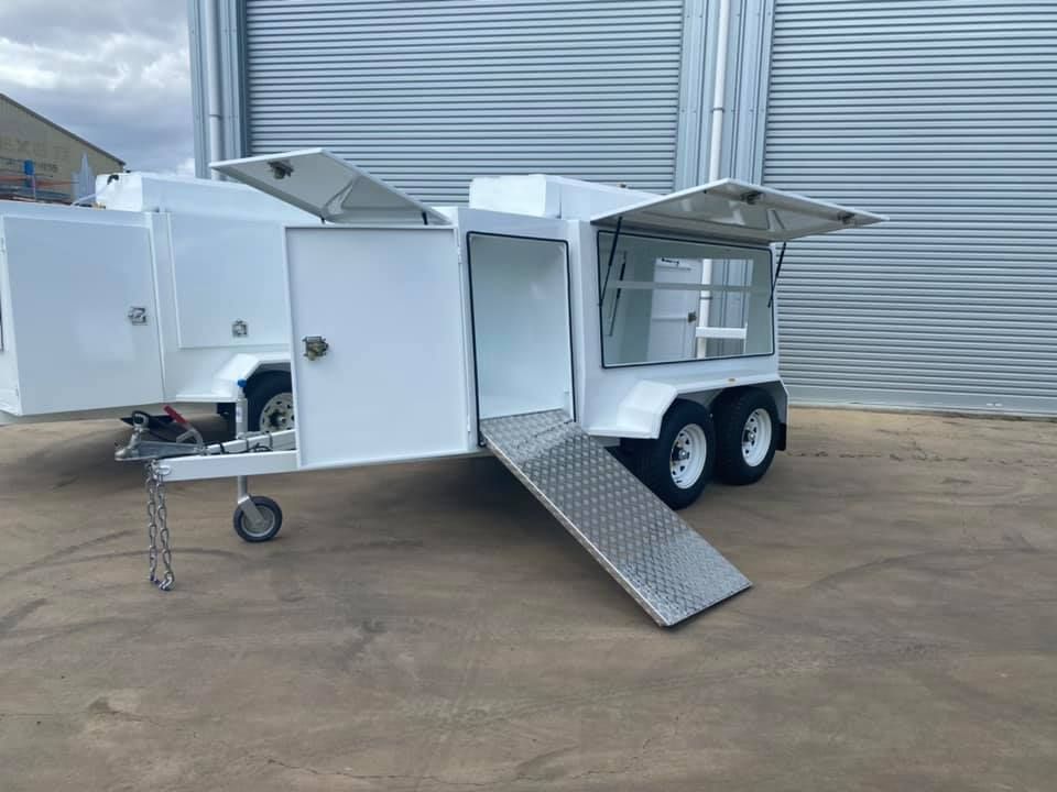 A White Trailer With a Ramp is Parked in Front of a Building  — SNS Custom Fabrication in Calliope, QLD