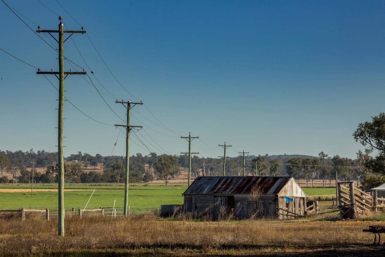 An Old Barn is Sitting in the Middle of a Field Next to Power Lines — SNS Custom Fabrication in Gracemere, QLD
