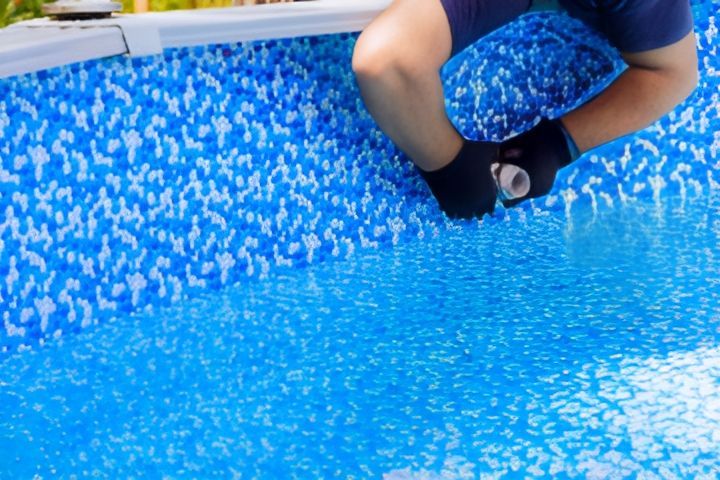 A Man is Repairing a Leak Inside a Swimming Pool — Col Davies Pools In Lake Macquarie, NSW