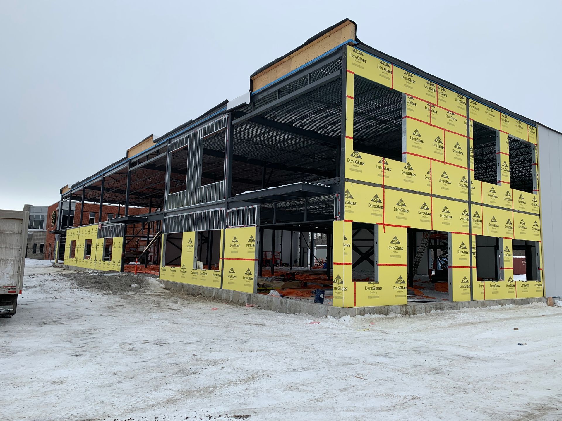 Un grand bâtiment est en construction sous la neige.
