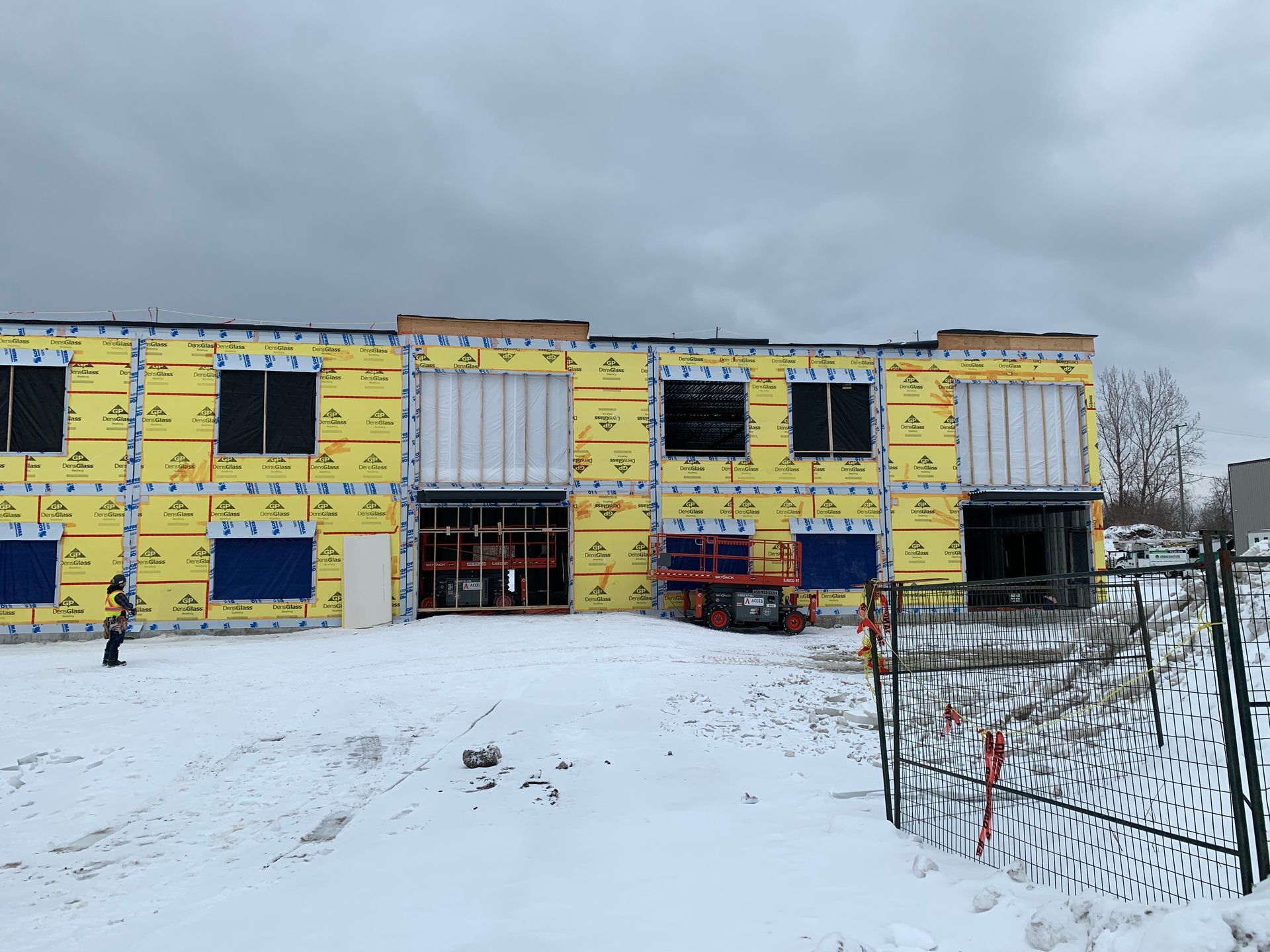 Un grand bâtiment est en construction sous la neige.