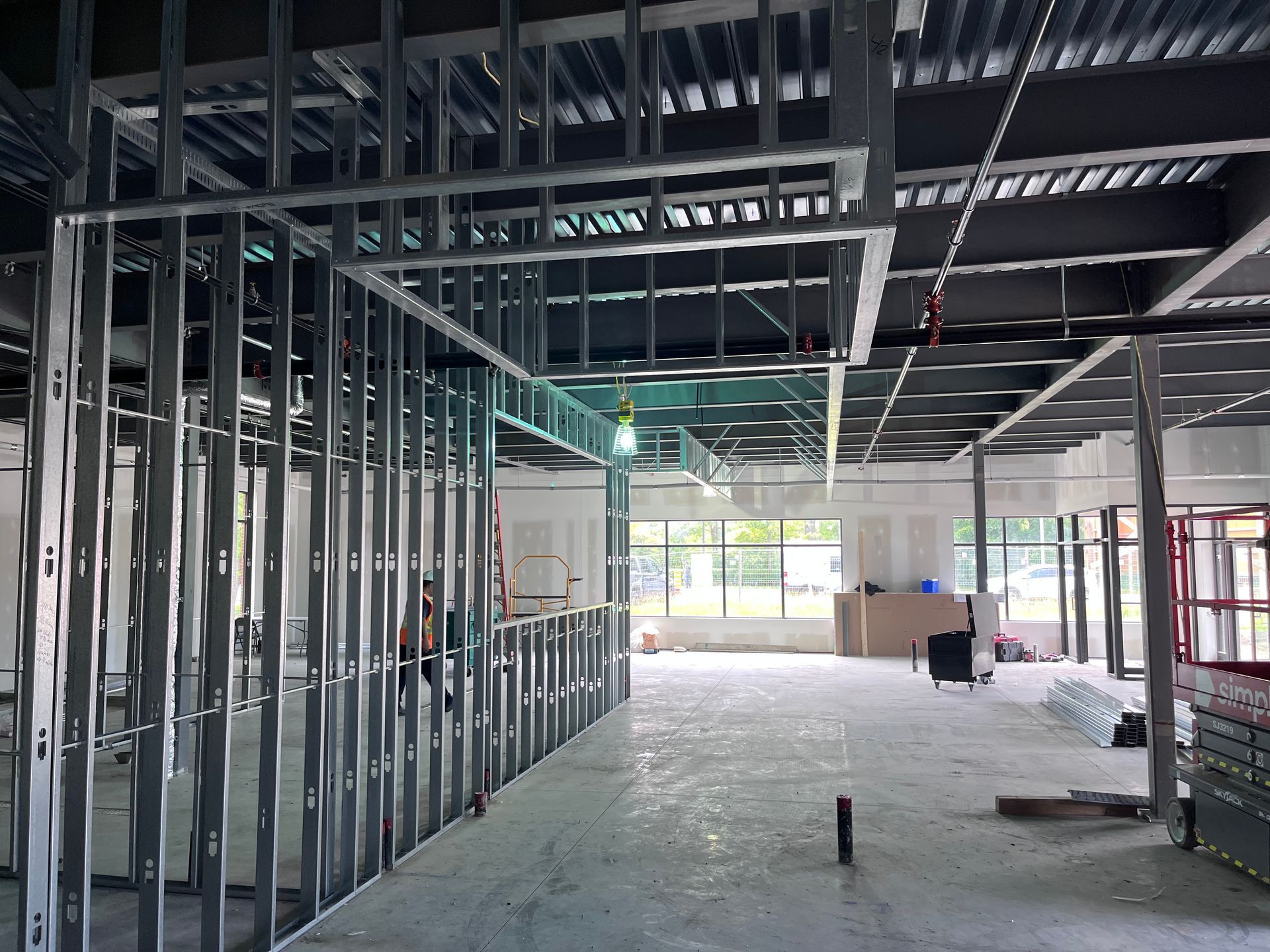 L'intérieur d'un bâtiment en construction avec beaucoup de charpentes métalliques.