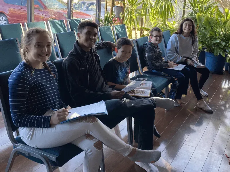 A group of people are sitting in chairs in a waiting room.