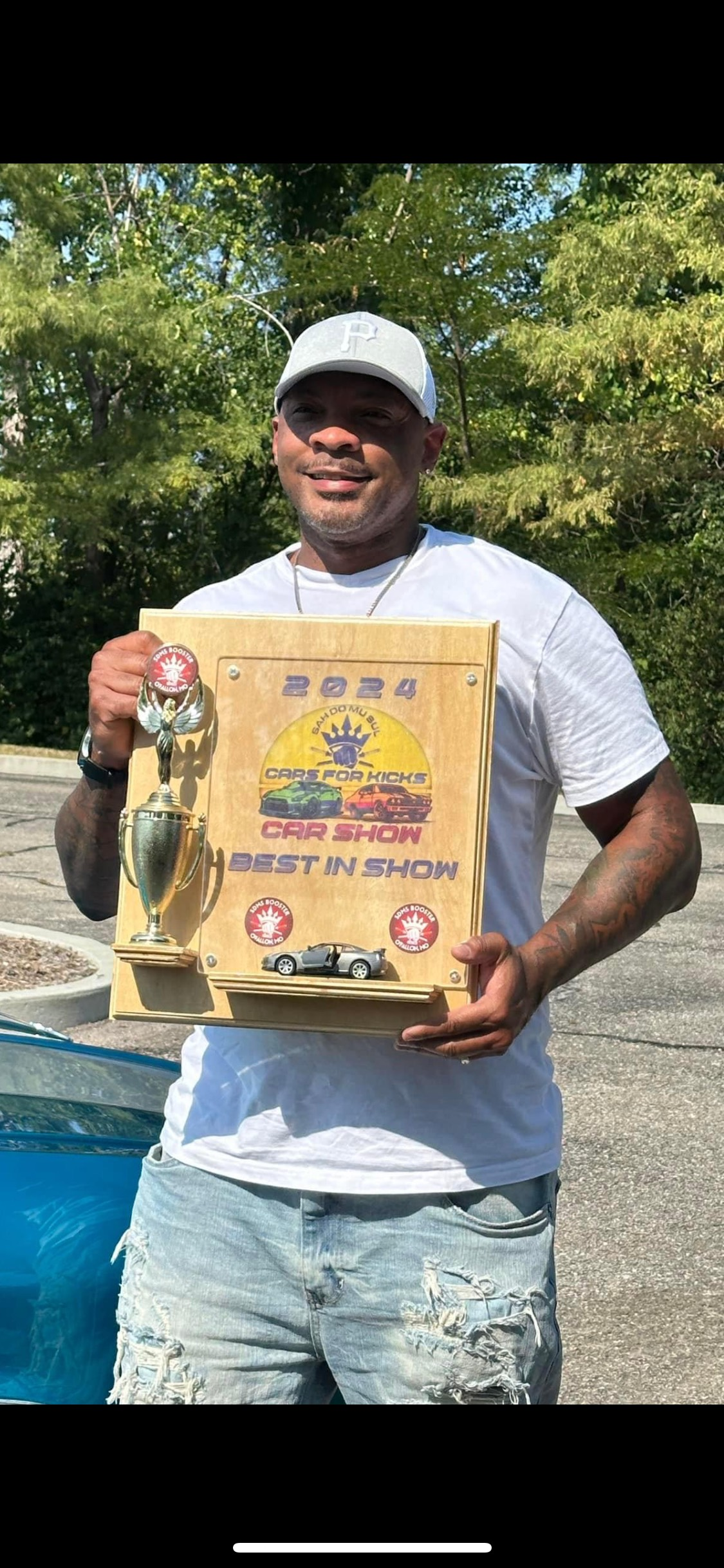 A man is holding a wooden plaque in his hands.