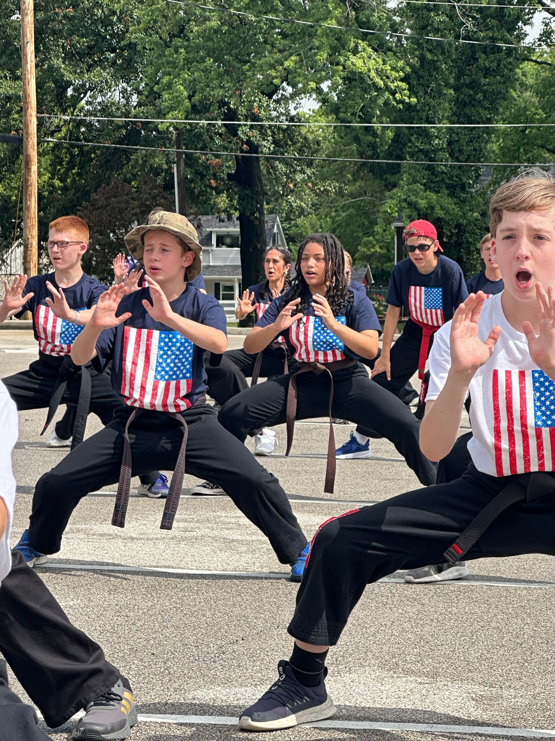 A group of young people are practicing martial arts on a street.