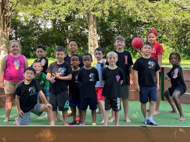 A group of children are posing for a picture in a park.