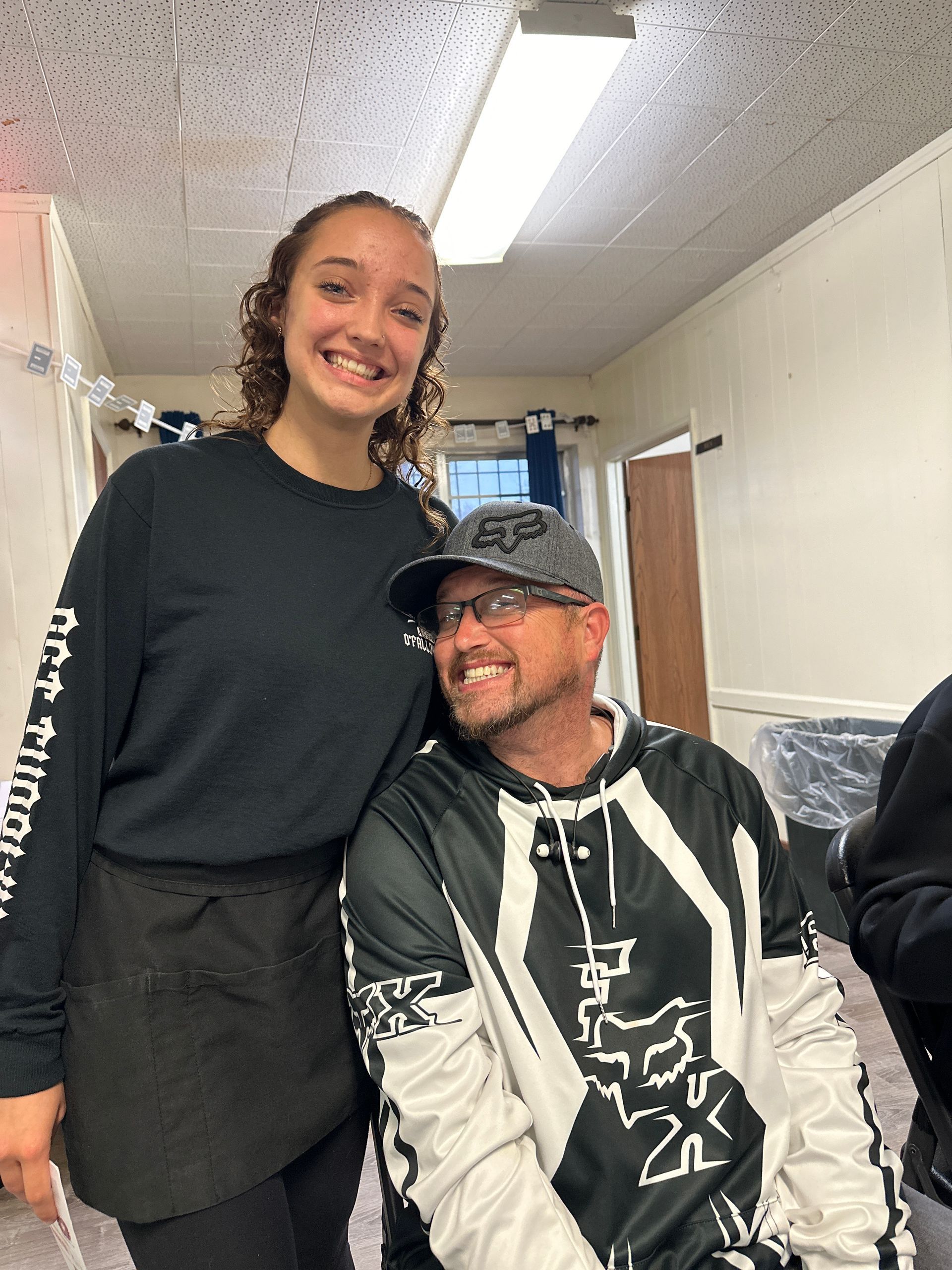 A man and a woman are posing for a picture in a room.