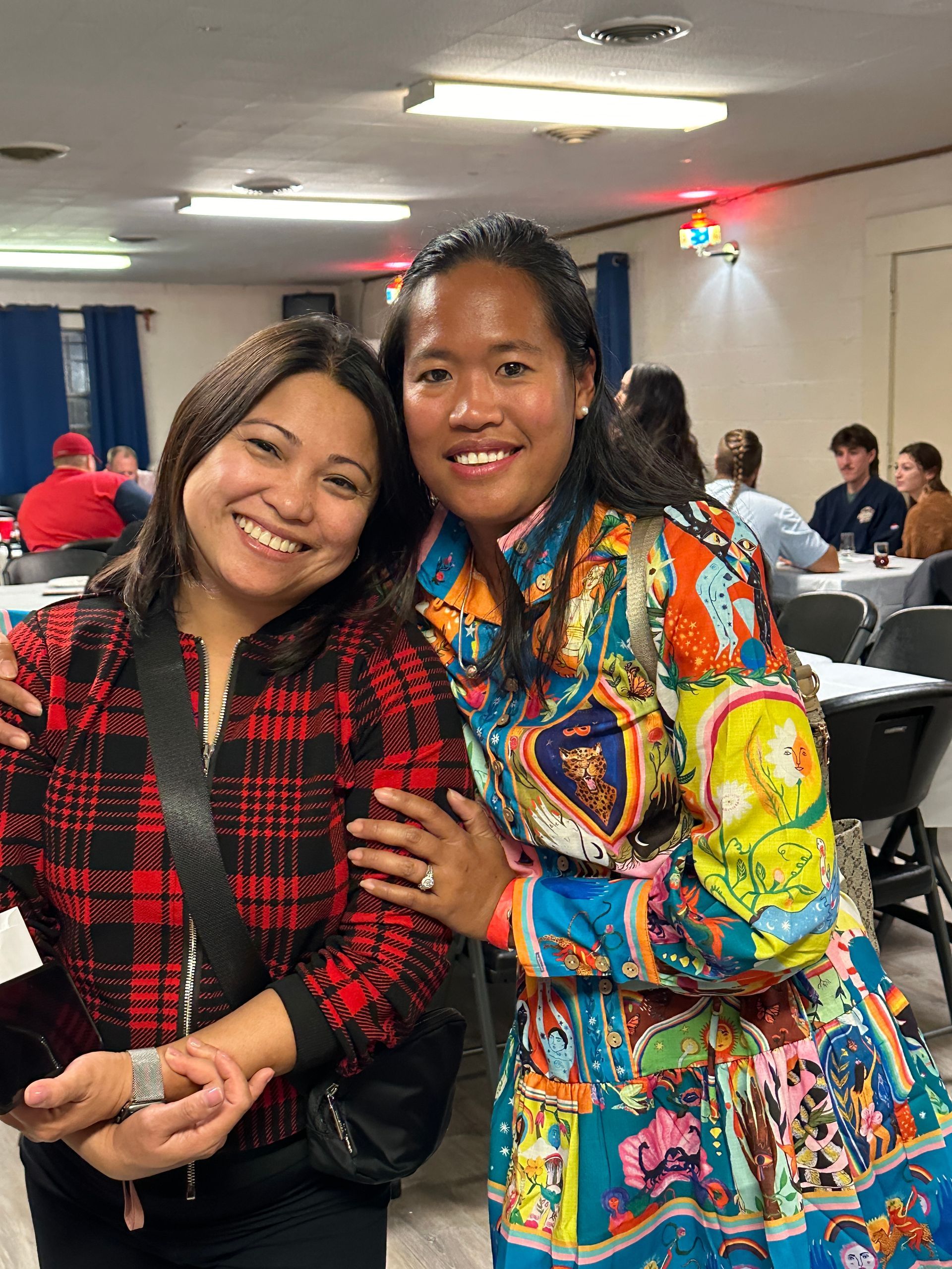 Two women are posing for a picture together in a room.