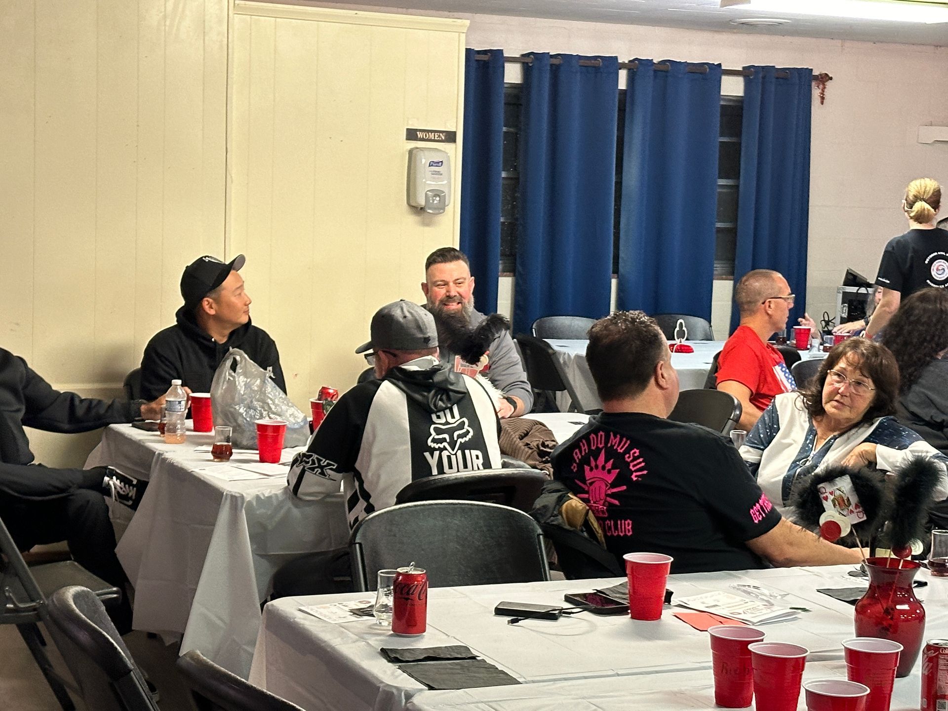 A group of people are sitting at tables in a room.