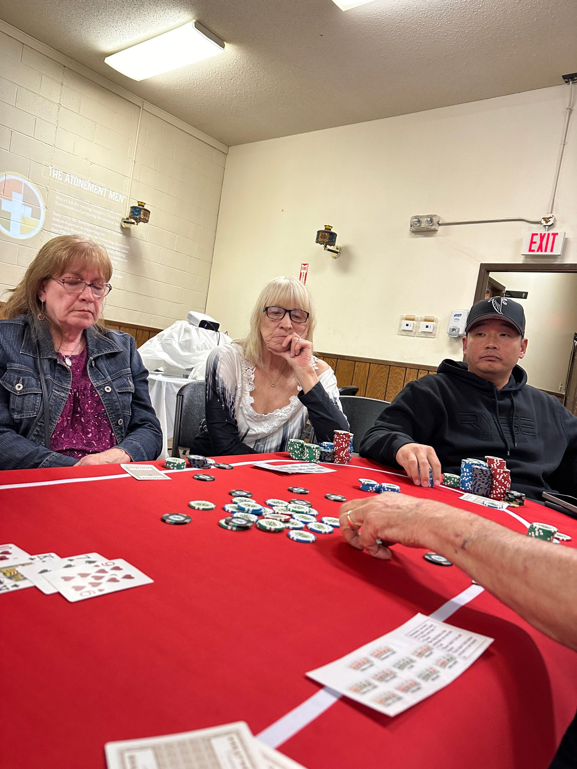 A group of people are sitting around a table playing poker.
