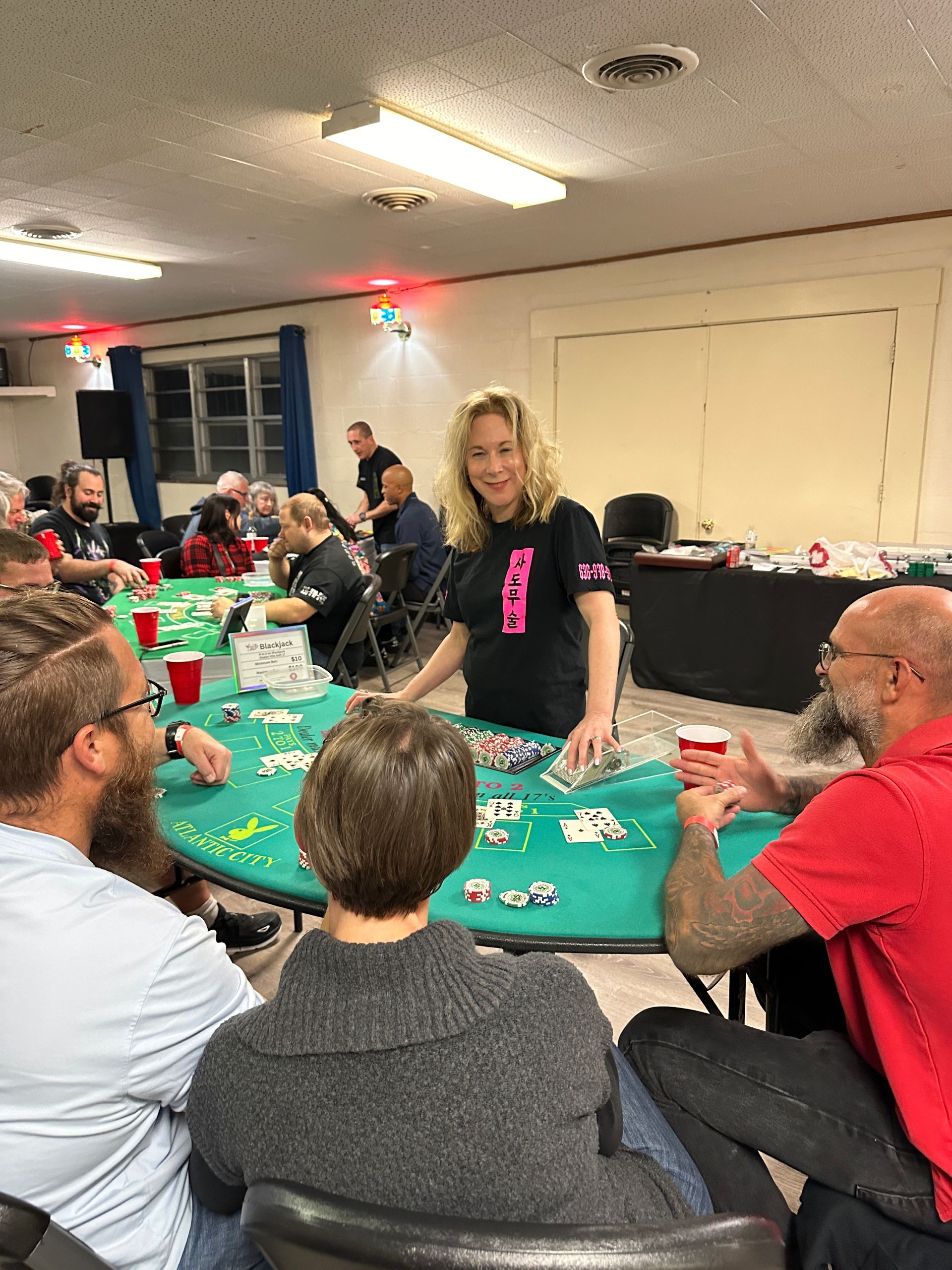 A group of people are sitting around a table playing cards.