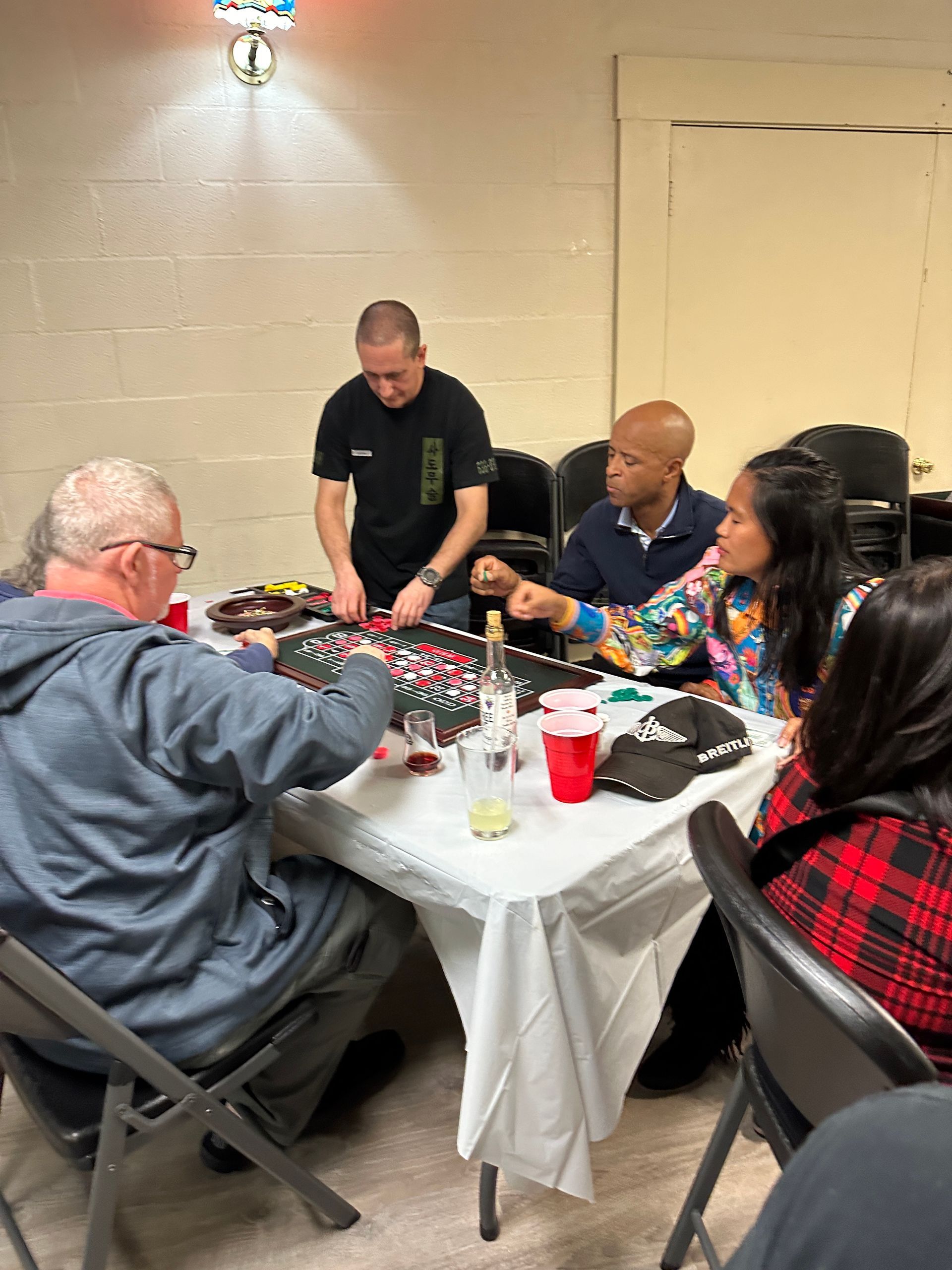 A group of people are sitting around a table playing a game.