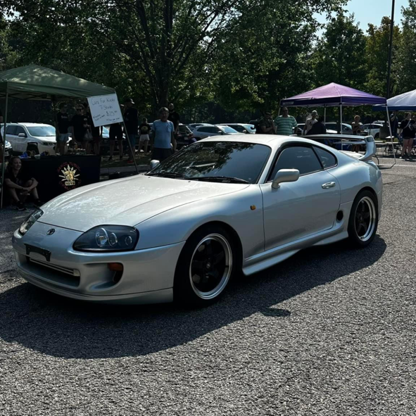 A silver sports car is parked in a parking lot