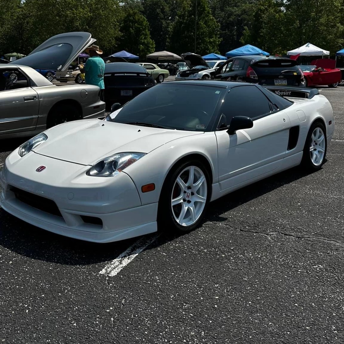 A white sports car is parked in a parking lot