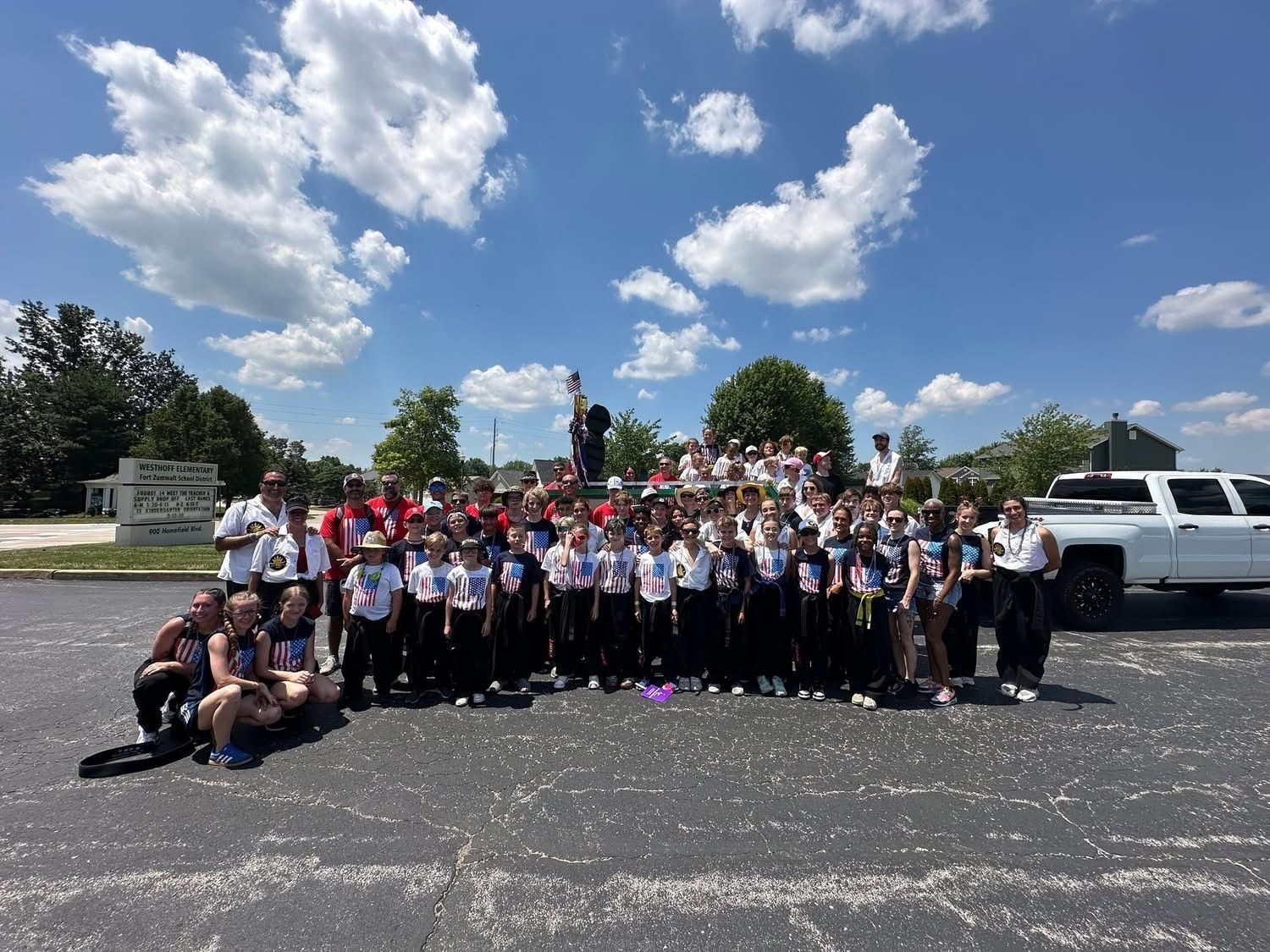 A large group of Sah Do Mu Sul students and instructors are posing for a picture in a parking lot.