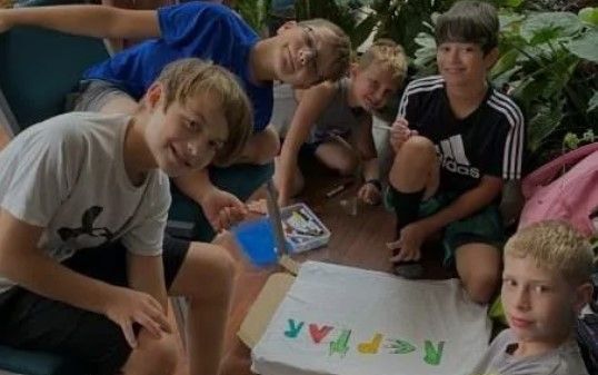 A group of young boys are sitting around a bag that says reppar on it.