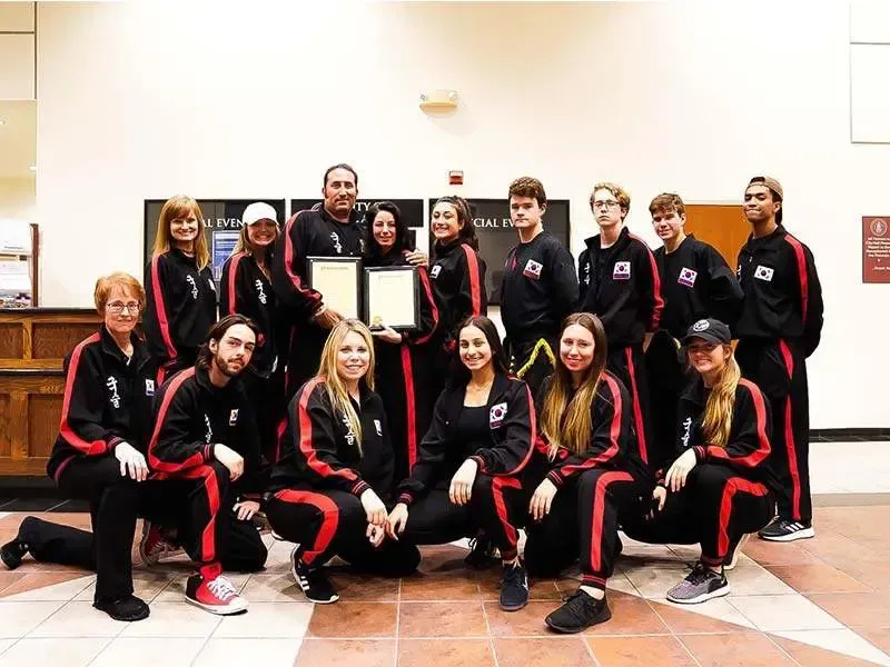 A group of people are posing for a picture in a room.