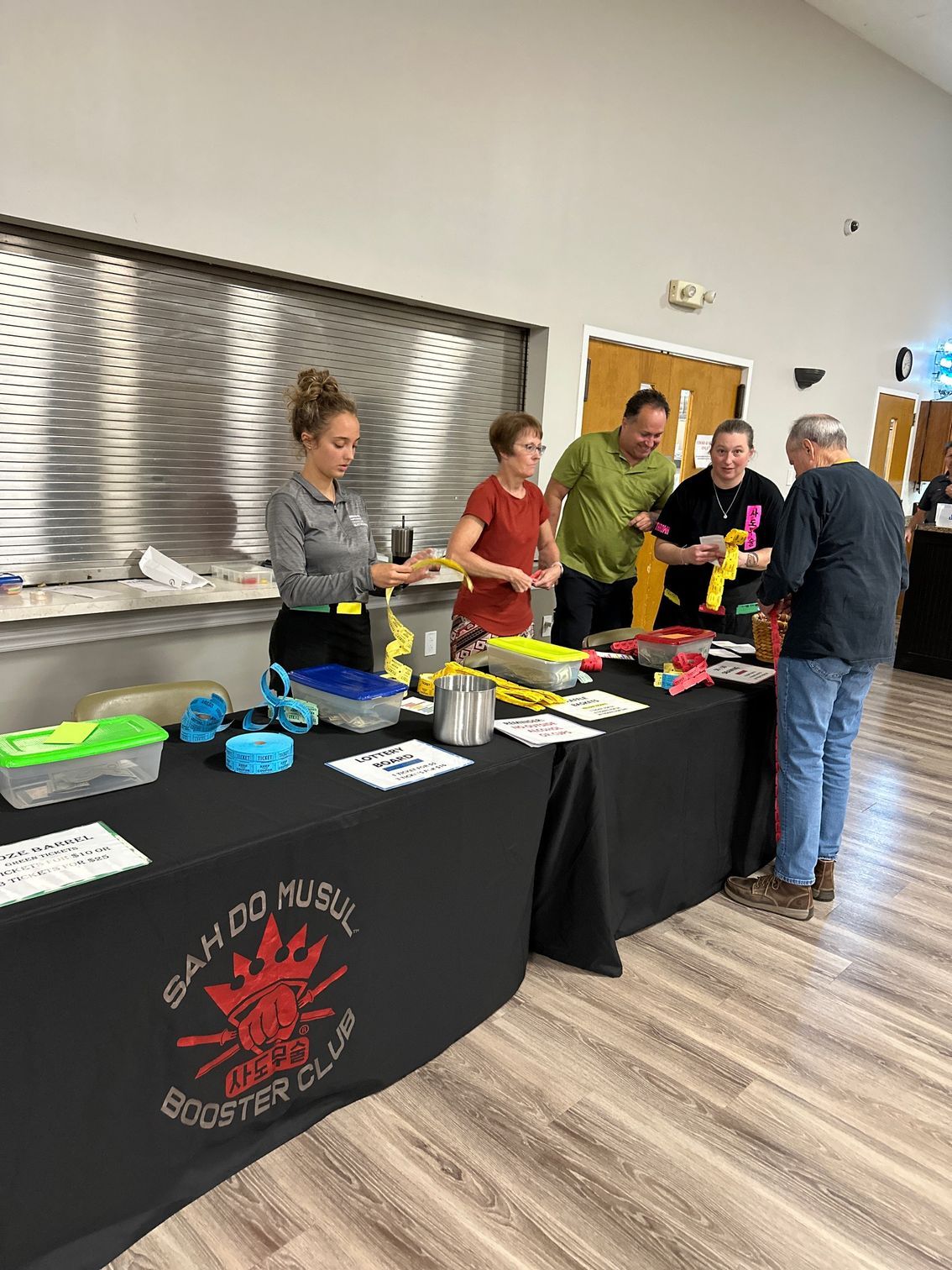A group of people are standing around a table in a room.