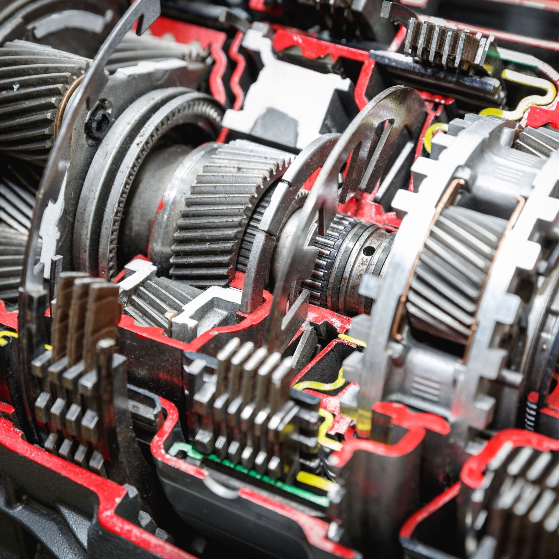 Close-up of exposed mechanical gears and gears in a red-and-black machine assembly