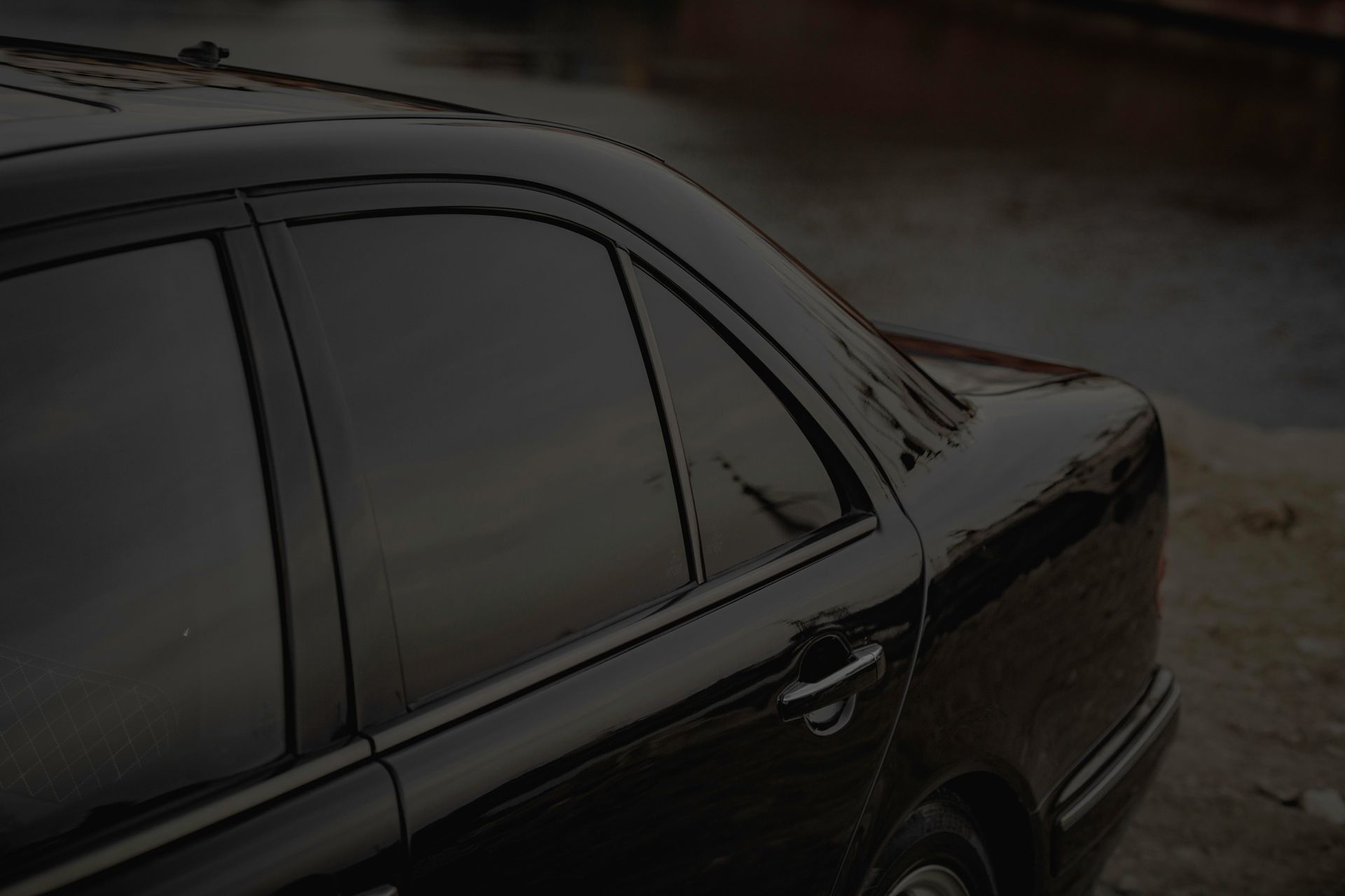 Black car with hood open, showing engine bay in a parking lot.