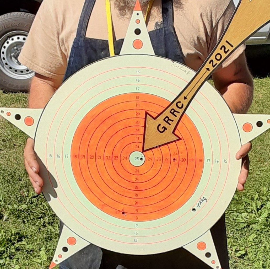 A man is holding a target that says grrc on it