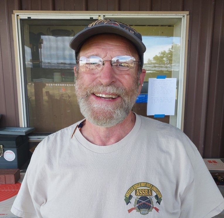 A man with a beard and glasses is wearing a t-shirt that says alaska on it