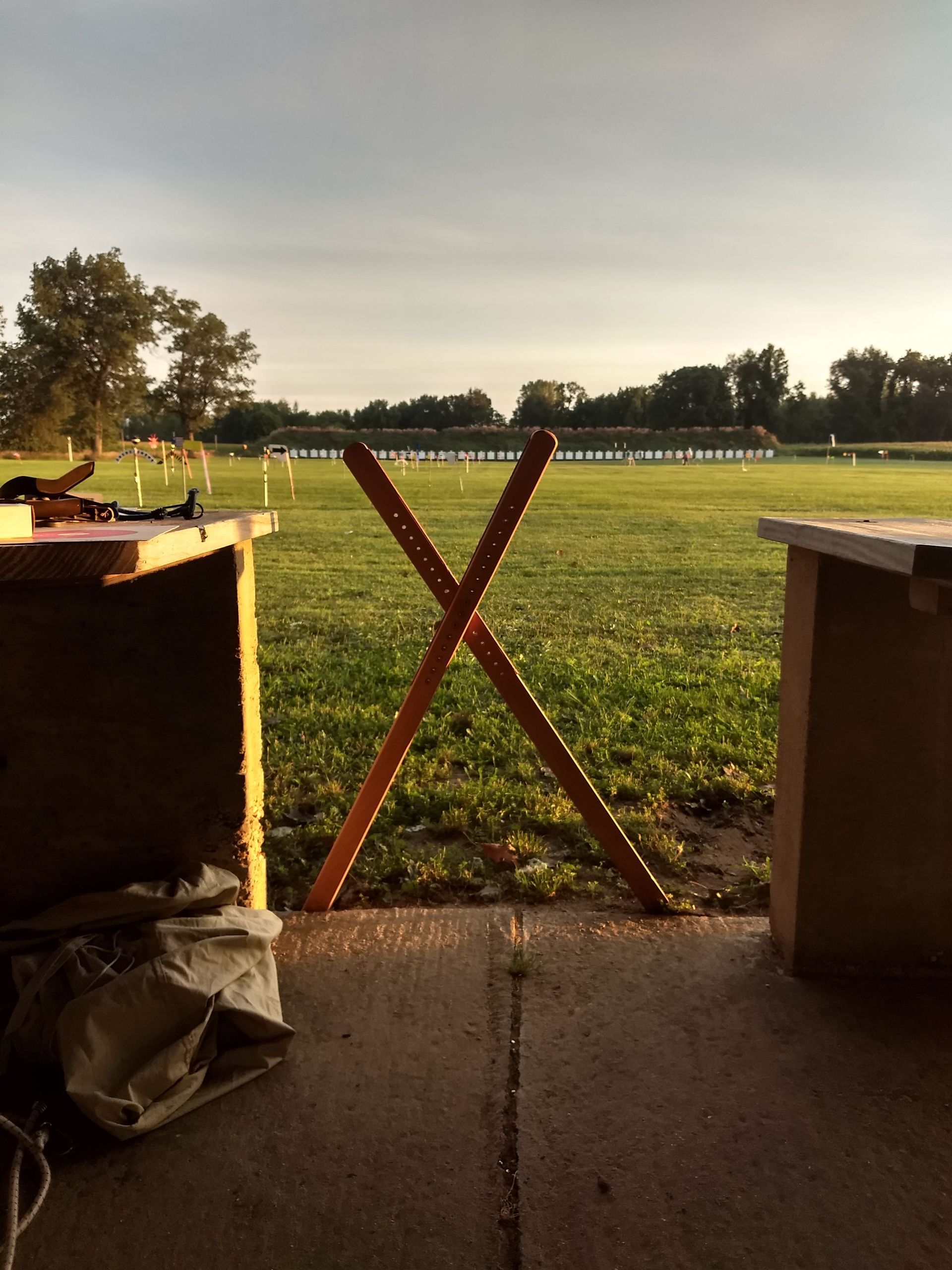 A wooden x is in the middle of a field