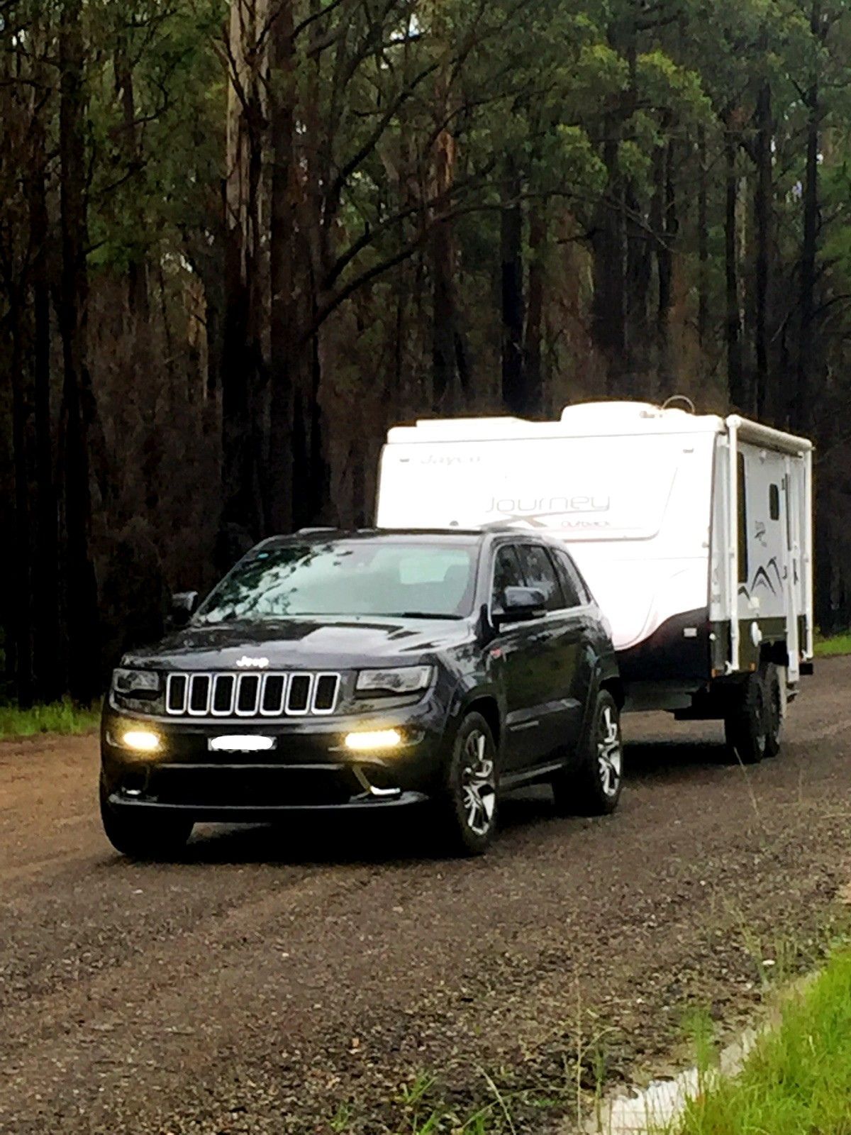 A Jeep Is Towing A Trailer Down A Dirt Road – Kempsey, NSW - Ezy Group Services