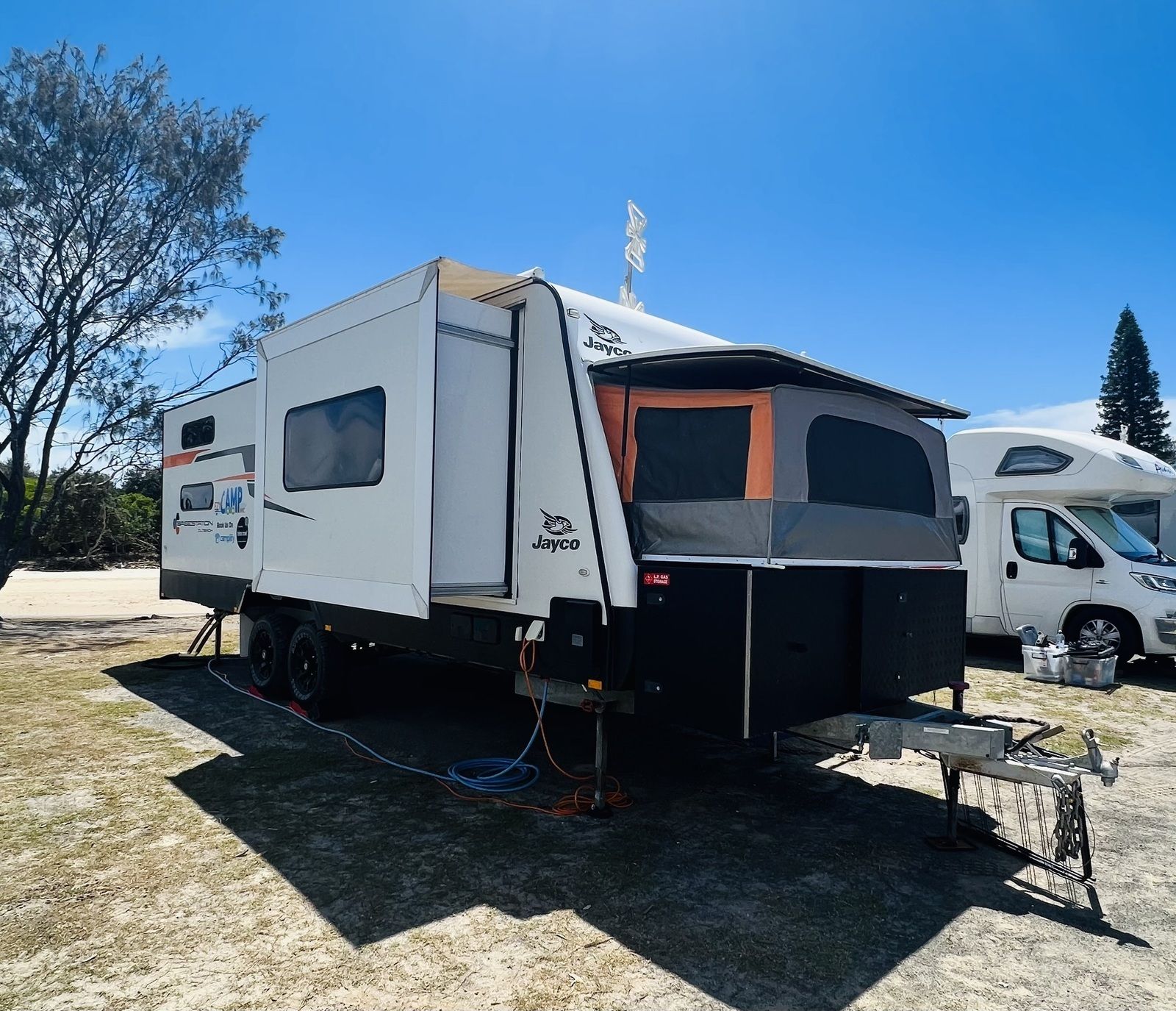 A Camper Trailer Is Parked In A Grassy Area Next To Other Camper Trailers – Kempsey, NSW - Ezy Group Services