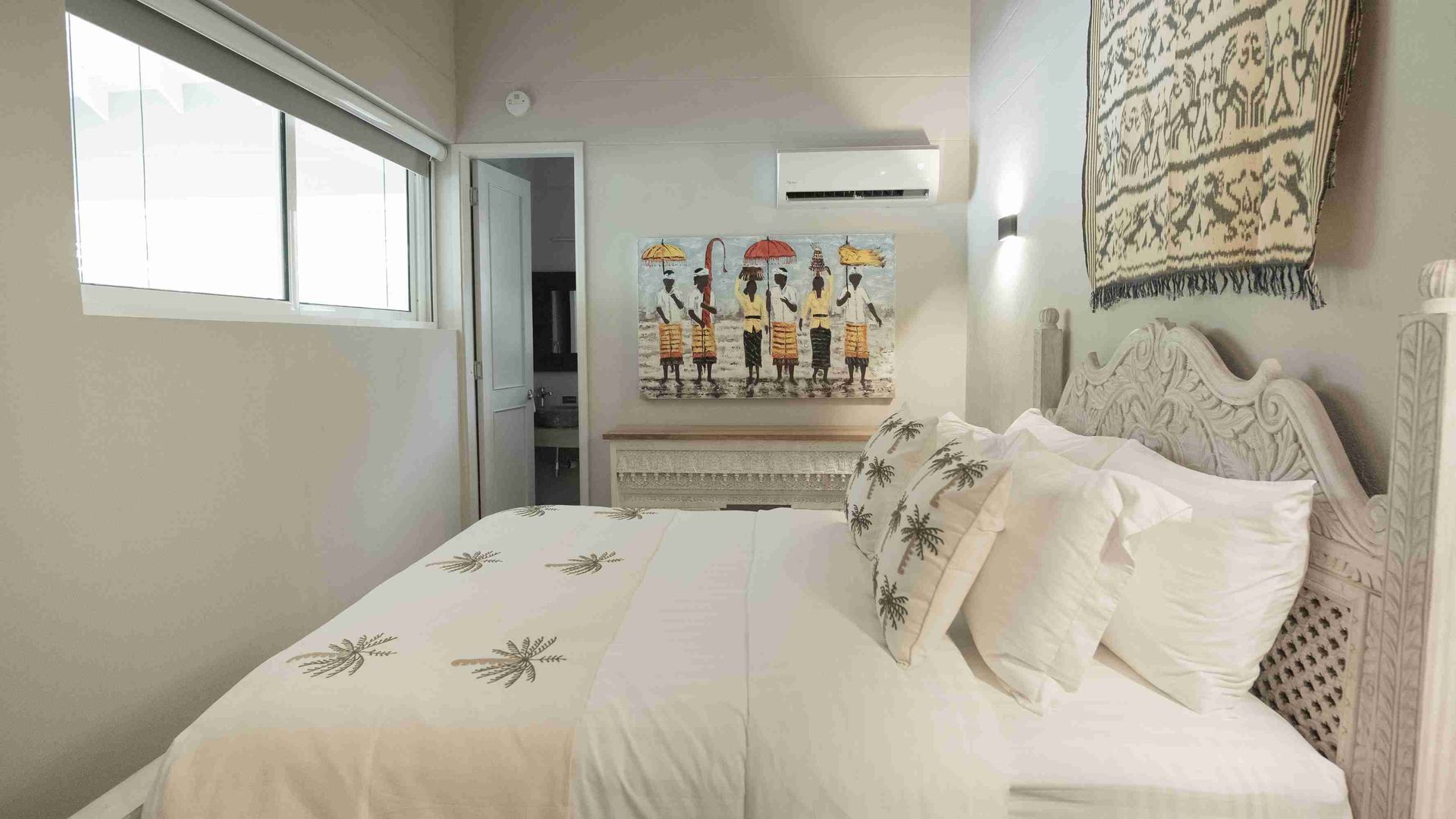 Habitación con cama doble, cojines decorativos y cuadro en la pared en hotel boutique en San Andrés.