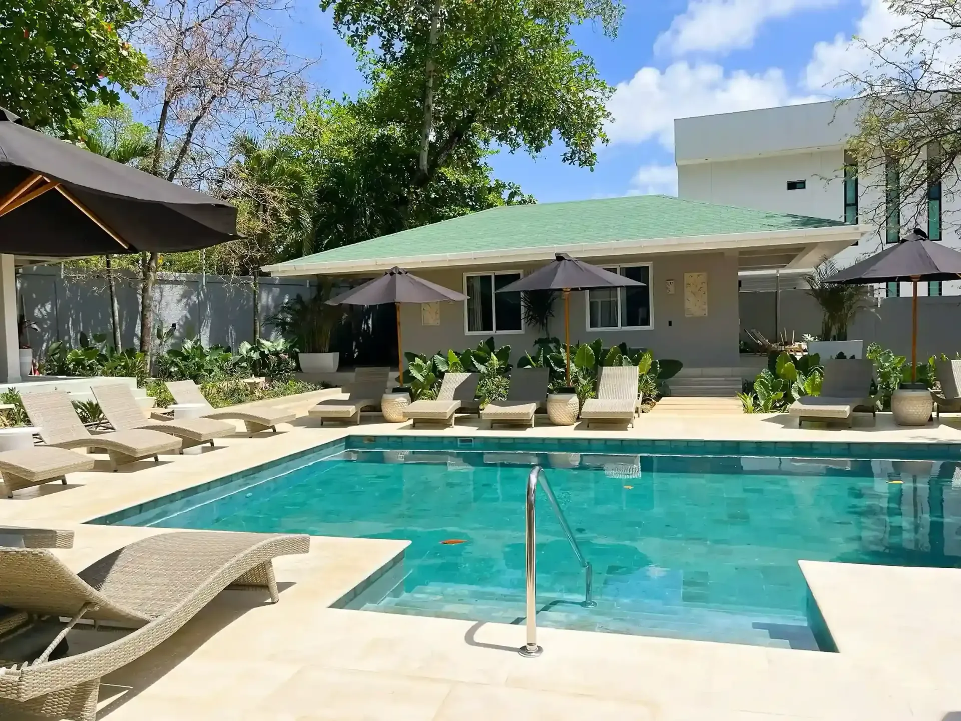 Piscina al aire libre en hotel en San Andrés, área de descanso con camastros, vegetación tropical y ambiente tranquilo.