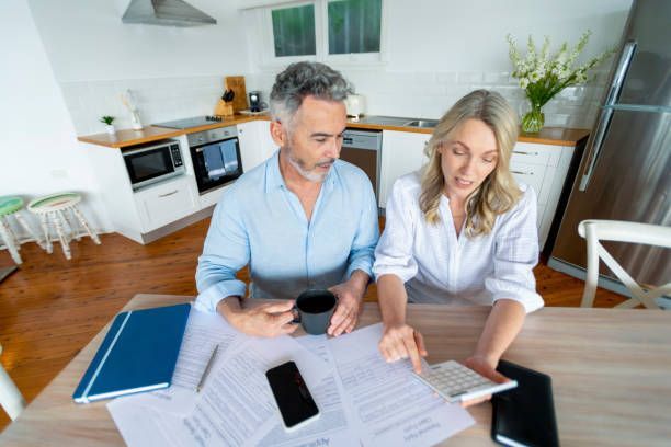 A man and a woman are sitting at a table looking at papers.