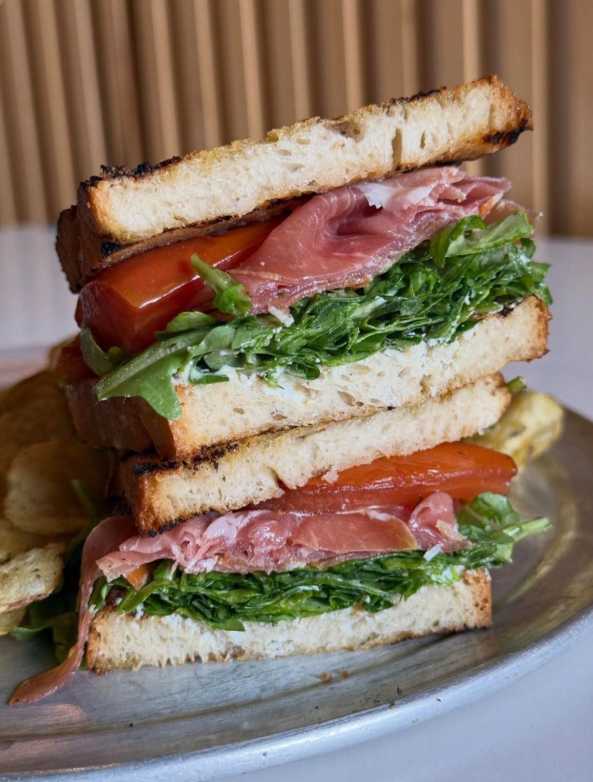 Prima Dopo Prosciutto di Parma, tomato confit, lemon ricotta, arugula, lemon honey vinaigrette on grilled sourdough